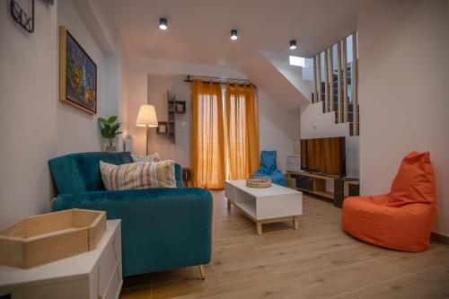 a living room with a blue couch and a chair at Serenity Karditsa Lofts in Kardítsa