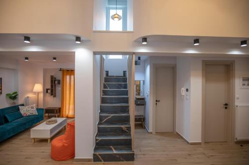 a staircase in a living room with a blue couch at Serenity Karditsa Lofts in Kardítsa