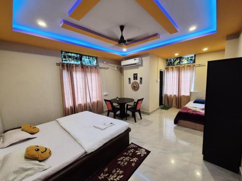 a bedroom with two beds and a table in it at Serene Dawn Homestay in Guwahati