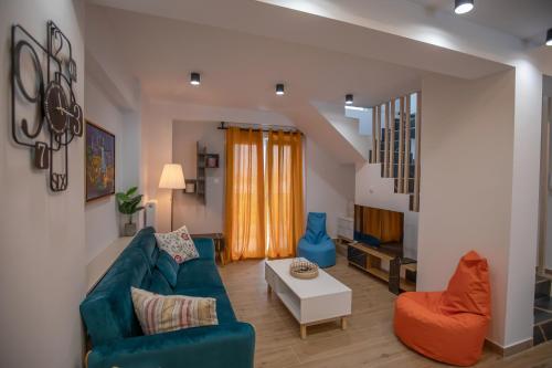 a living room with a blue couch and orange chairs at Serenity Karditsa Lofts in Kardítsa