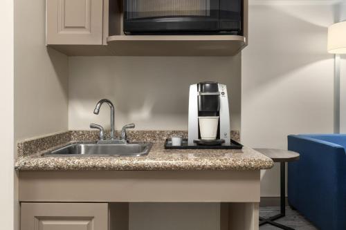 a kitchen counter with a sink and a coffee maker at Holiday Inn Express Hotel & Suites Brockville by IHG in Brockville
