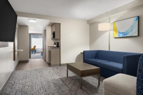 a living room with a blue couch and a table at Holiday Inn Express Hotel & Suites Brockville by IHG in Brockville