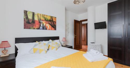 a bedroom with a large bed with a yellow blanket at Lioda Rite in Masariè