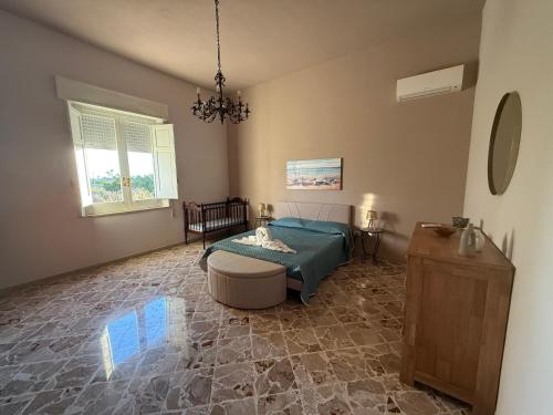 a bedroom with a bed and a table and a chandelier at Villa Sole in Petrosino