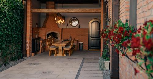 an outdoor patio with a wooden table and chairs at Strindberg Boutique Hotel in Topliţa