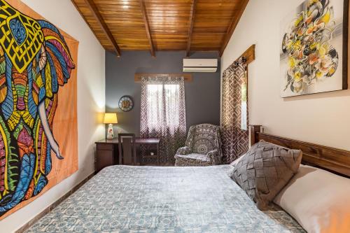 a bedroom with a bed and a painting on the wall at Intimate Earthy Vibe - Bedroom in a Tropical Paradise in Herradura