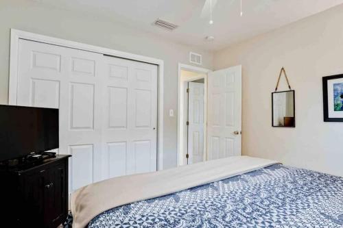 a bedroom with a bed and a flat screen tv at Great Shape After Milton -gorgeous Pool! - Os in Venice