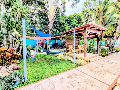 a hammock in a garden with a gazebo at Intimate Earthy Vibe - Bedroom in a Tropical Paradise in Herradura