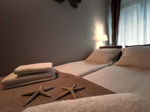 two beds with towels and star cushions on them at Apartament Toruń Orbita free parking in Toruń