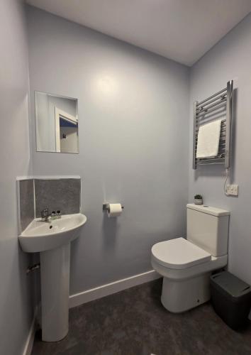 a white bathroom with a toilet and a sink at The Railway Inn in Kyle of Lochalsh