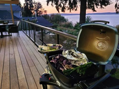 a grill with a plate of food on a deck at 3 Bed Gorgeous Views Hot Tub Dog Friendly Ada in Langley