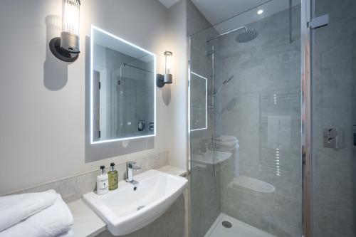 a bathroom with a sink and a glass shower at The Ship Hotel in Southend-on-Sea