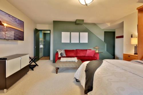 a bedroom with a large bed and a red couch at 3 Bed Gorgeous Views Hot Tub Dog Friendly Ada in Langley