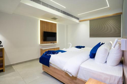 a bedroom with a white bed with blue pillows at Blue Moon Alleppey in Alleppey
