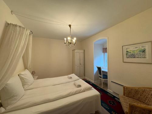 a bedroom with two beds and a chandelier at Liselund Ny Slot Hotel in Borre