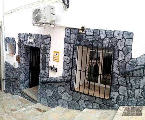 a building with a stone wall with a window at Apartamento La Cueva in Algarrobo