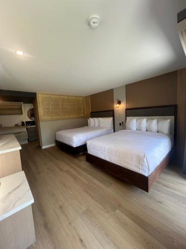 two beds in a hotel room with wooden floors at Lamp Liter Inn in Visalia