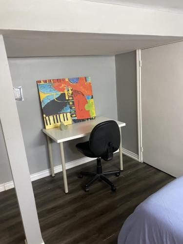 a desk with a painting and a chair in a room at Oasis Of Peace in Hamilton