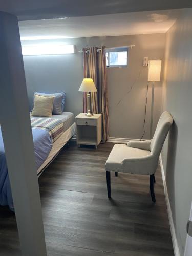 a bedroom with a bed and a chair and a lamp at Oasis Of Peace in Hamilton