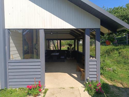 a large white shed with a door and windows at Saduba Pushkarivchyk in Yablunytsya