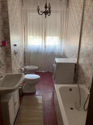 a bathroom with a sink and a toilet and a tub at Appartamento Mare Monti in Carrara