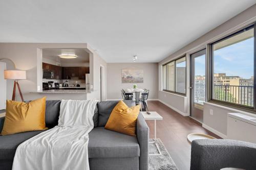 a living room with a gray couch with yellow pillows at Boutique DCA Unit-Sleeps 7-Free Parking-Great Spot in Arlington