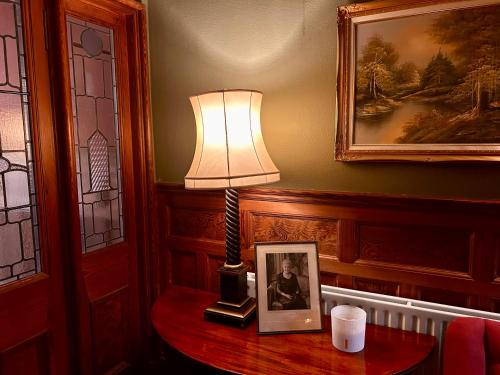 a lamp on a table with a picture on it at Clashmore House in Dornoch