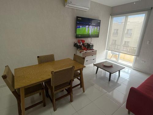 a living room with a dining room table and a tv at Tulum confort in Tulum
