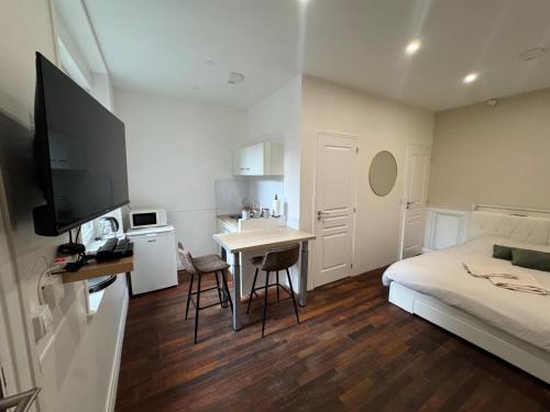 a small room with a bed and a desk with a table at Le Cottage du Centre in Boulogne-sur-Mer