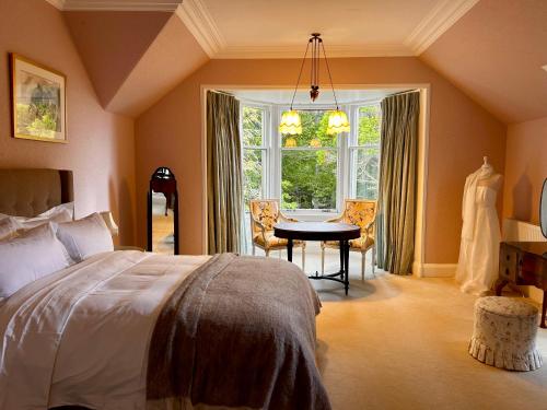 a bedroom with a bed and a table and a window at Clashmore House in Dornoch