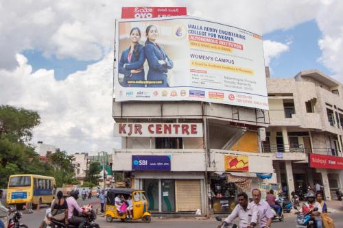 a sign on the side of a building on a busy street at Hotel O Shannu Residency in Secunderabad