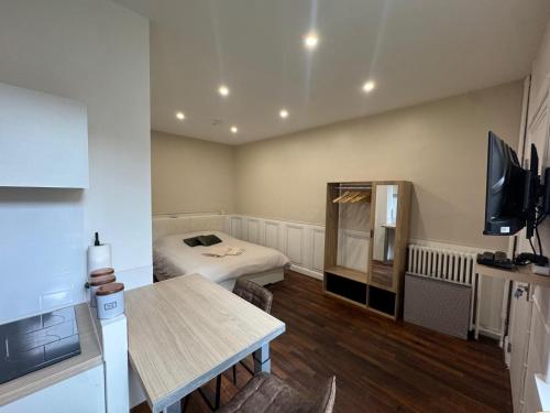a small room with a bed and a table at Le Cottage du Centre in Boulogne-sur-Mer