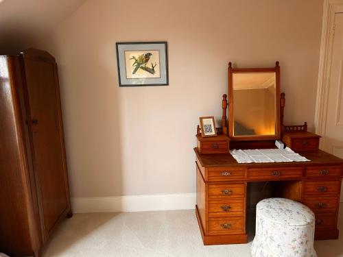 a bathroom with a wooden dresser with a mirror at Clashmore House in Dornoch