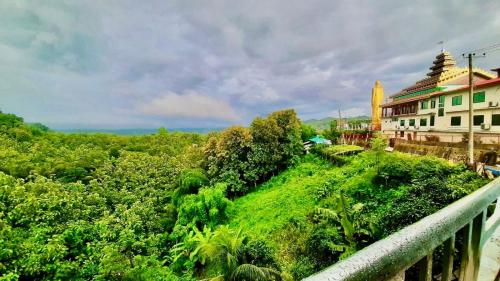 a view of a hill with a building and trees at Cloudy Inn Resort in Bāndarban