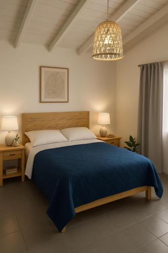 a bedroom with a blue bed and a chandelier at Casa Quinta Estilo Casa de Campo in General Rodríguez