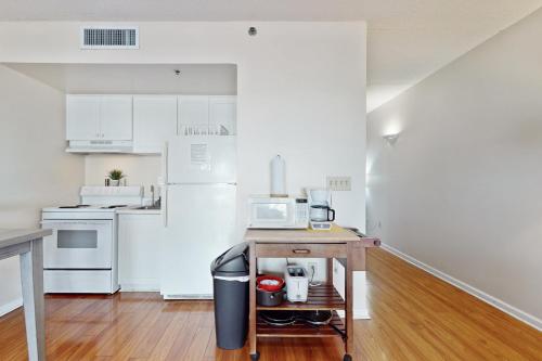 a kitchen with white cabinets and a table with a microwave at Water Street Condos Unit 208 in Wilmington