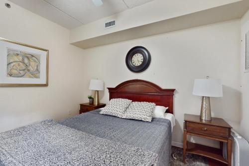a bedroom with a bed and a clock on the wall at Water Street Condos Unit 208 in Wilmington