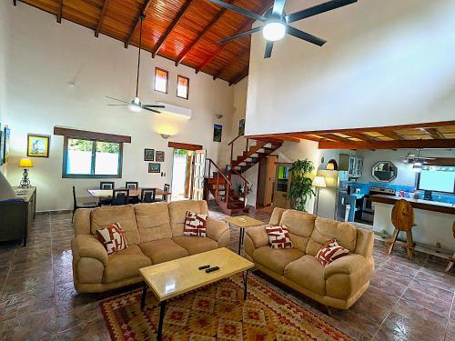 a living room with two couches and a table at Lovely Tropical Ensuite Bedroom - Pool AC Hot Water in Herradura