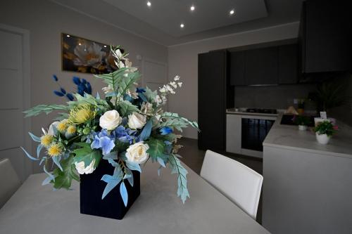 a vase of flowers on a table in a kitchen at Plaza Rooms Luxury B&B in Pagani