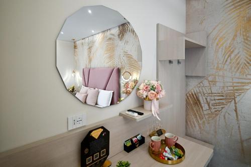 a room with a mirror and a table with flowers at Plaza Rooms Luxury B&B in Pagani