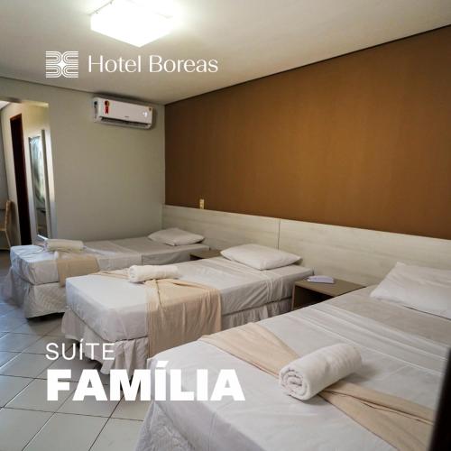 a room with four beds in a hotel room at Hotel Boreas in Fortaleza