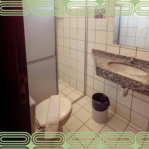 a bathroom with a toilet and a sink at Hotel Boreas in Fortaleza