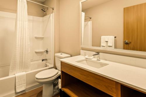 a bathroom with a sink and a toilet and a mirror at LivAway Suites Salt Lake City- Draper in Draper