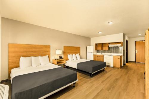 a hotel room with two beds and a kitchen at LivAway Suites Salt Lake City- Draper in Draper