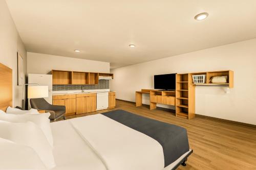 a hotel room with a bed and a kitchen at LivAway Suites Salt Lake City- Draper in Draper
