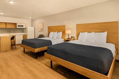 a hotel room with two beds and a kitchen at LivAway Suites Salt Lake City- Draper in Draper