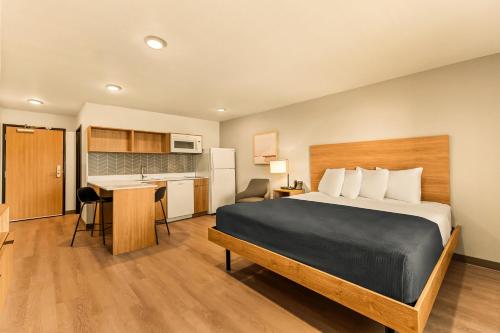 a hotel room with a bed and a kitchen at LivAway Suites Salt Lake City- Draper in Draper