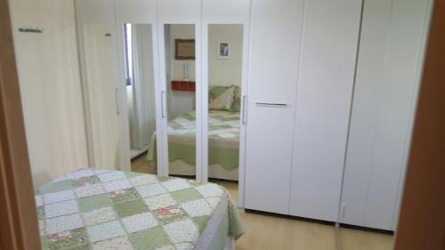 um pequeno quarto com uma cama e um espelho em Flat em Boa Viagem em Recife