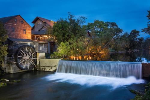 a waterfall in front of a house with a waterwheel at 1 Above the Smokies by American Patriot Getaways in Williamsburg