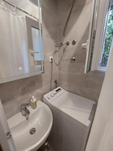 a bathroom with a sink and a toilet and a shower at Apartman Silvija Čiovo in Slatine